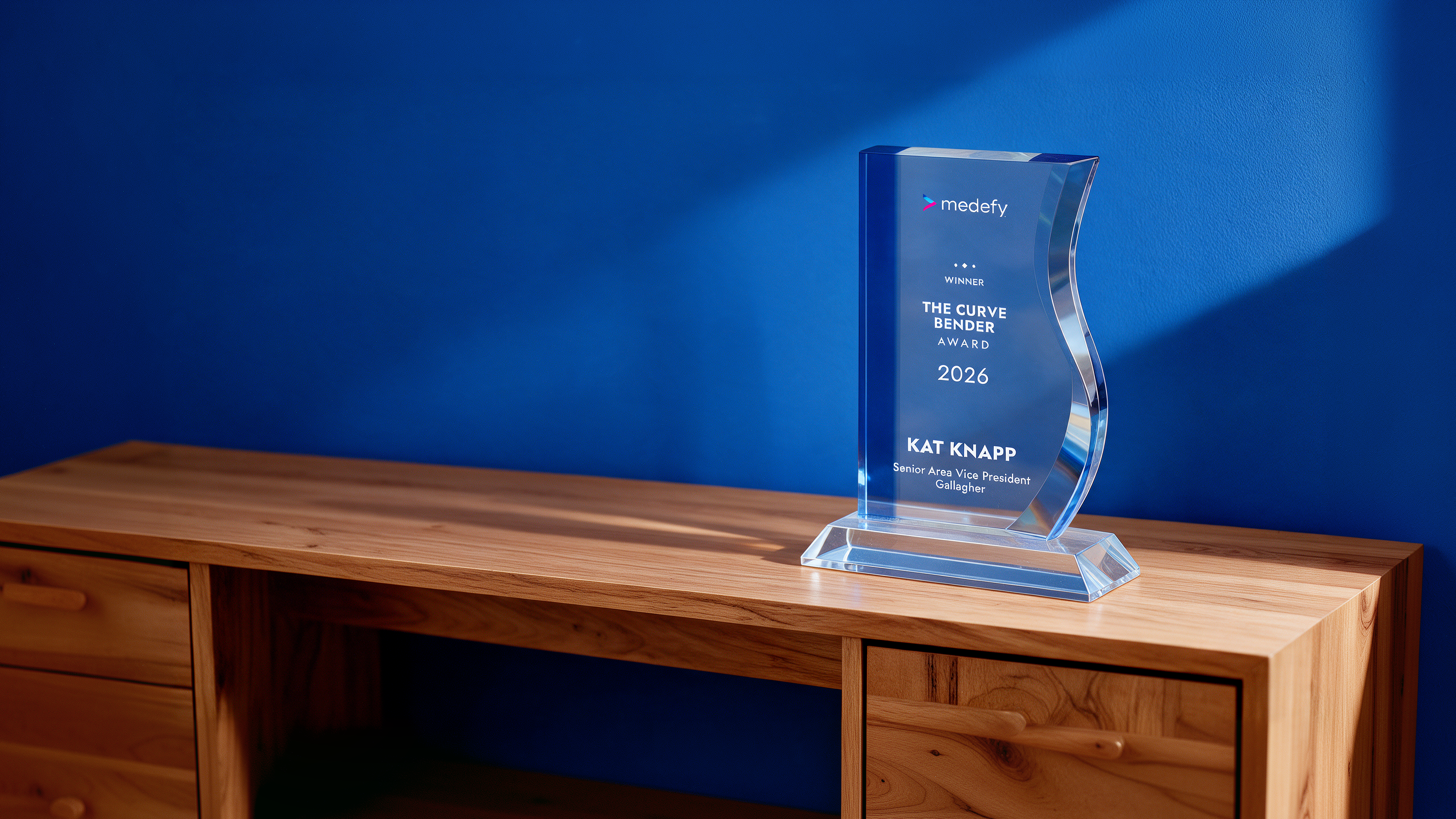 The Curve Bender Award trophy on a wooden desk